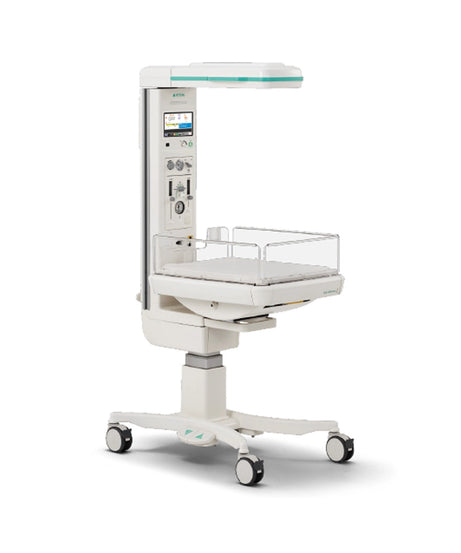 A white medical infant incubator on a wheeled base with an attached vertical control column, digital display screen, and clear plastic safety guard, shown on a clean white background.