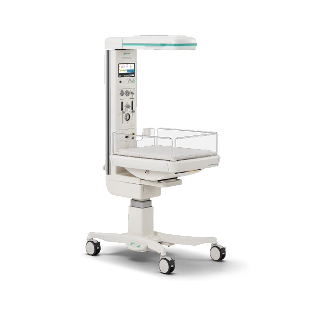 A white medical infant incubator on a wheeled base with an attached vertical control column, digital display screen, and clear plastic safety guard, shown on a clean white background.