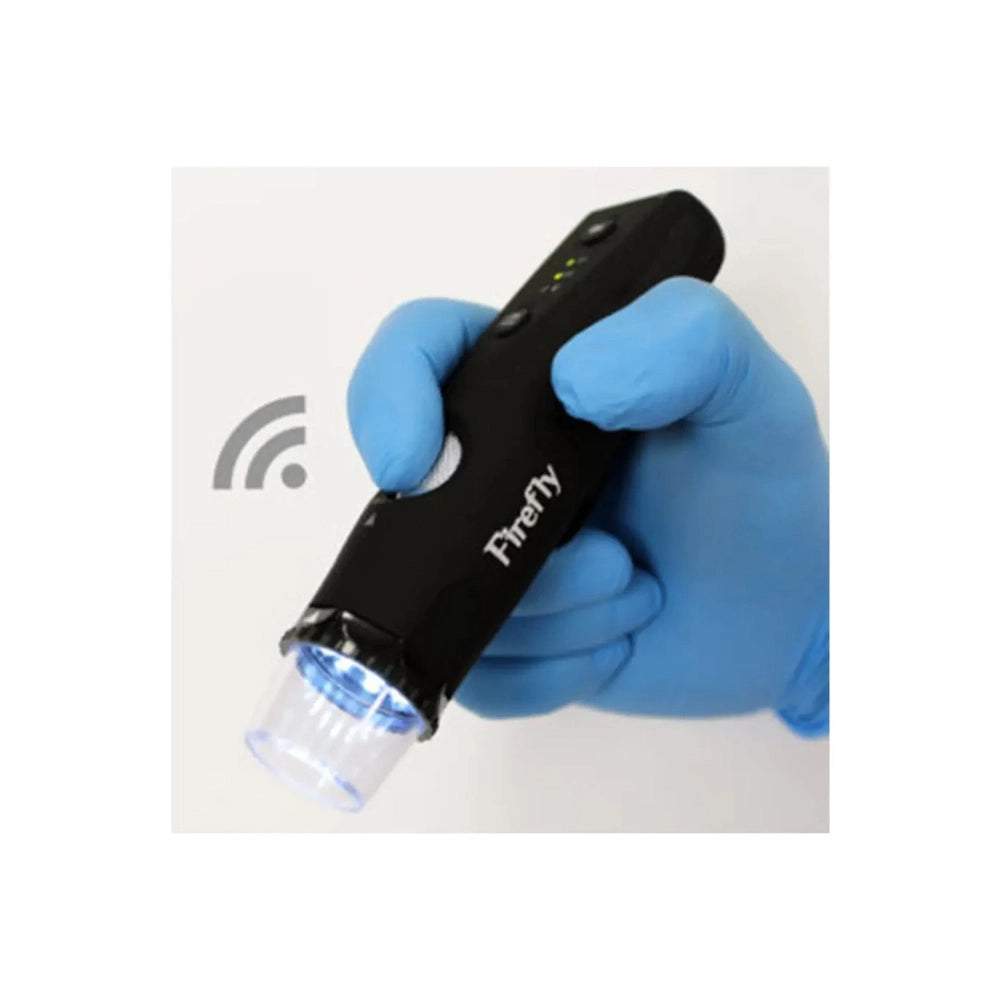 A black handheld Firefly device with a clear tip, held in a hand wearing a blue nitrile glove. The device has a white logo and a small green LED indicator light.
