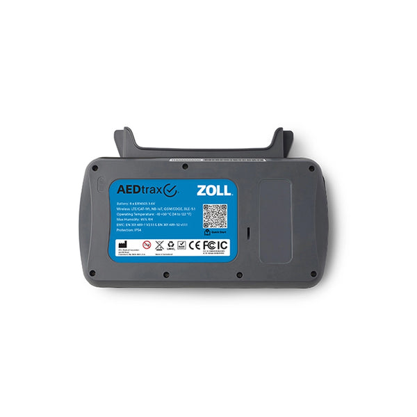 The back of a ZOLL AEDirax portable defibrillator device, showing the gray plastic casing, hinged top, and a blue label with regulatory text and a QR code, on a white background.